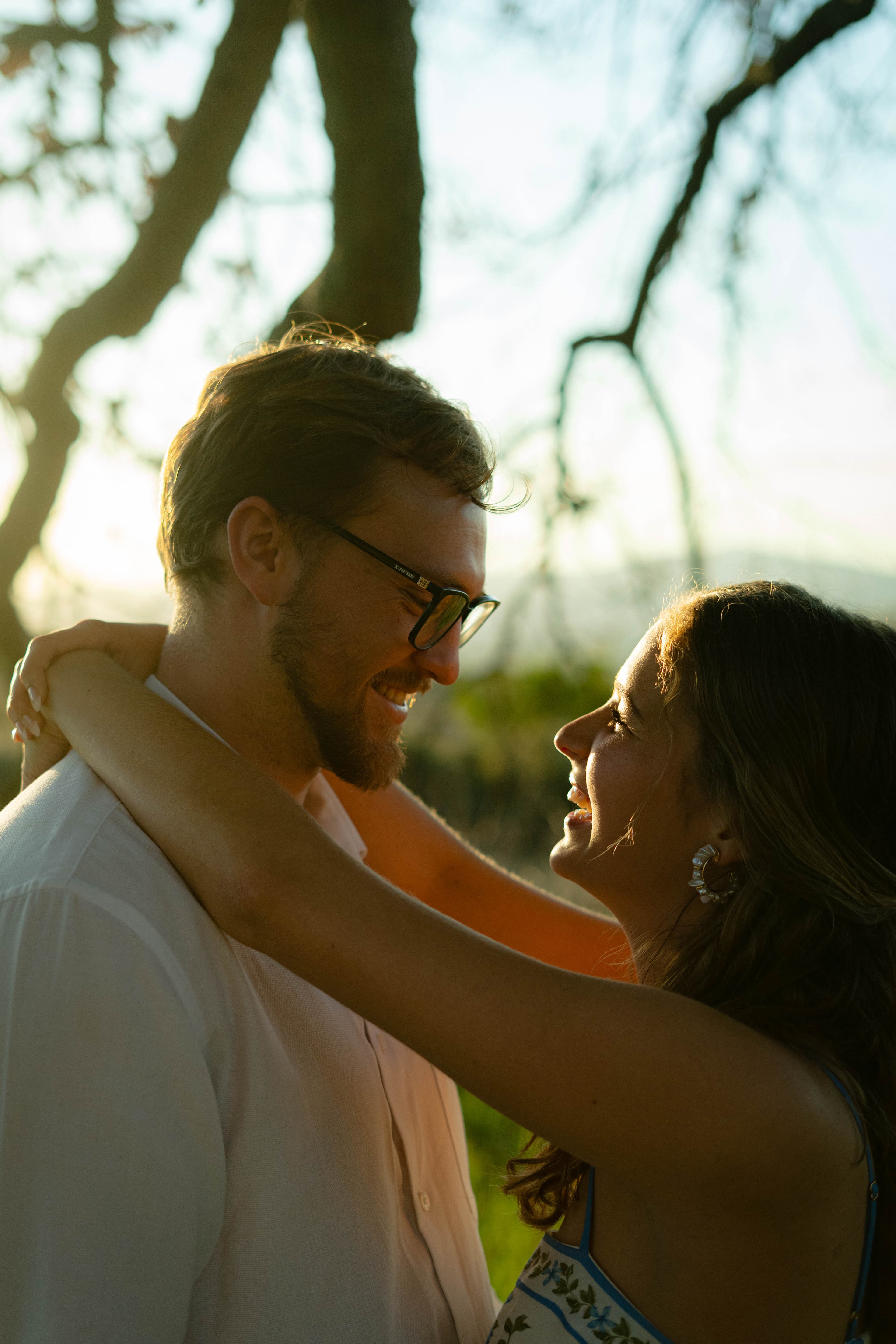 Reinhardt and Minke sharing a quiet moment outdoors, framed by trees in golden evening light.
