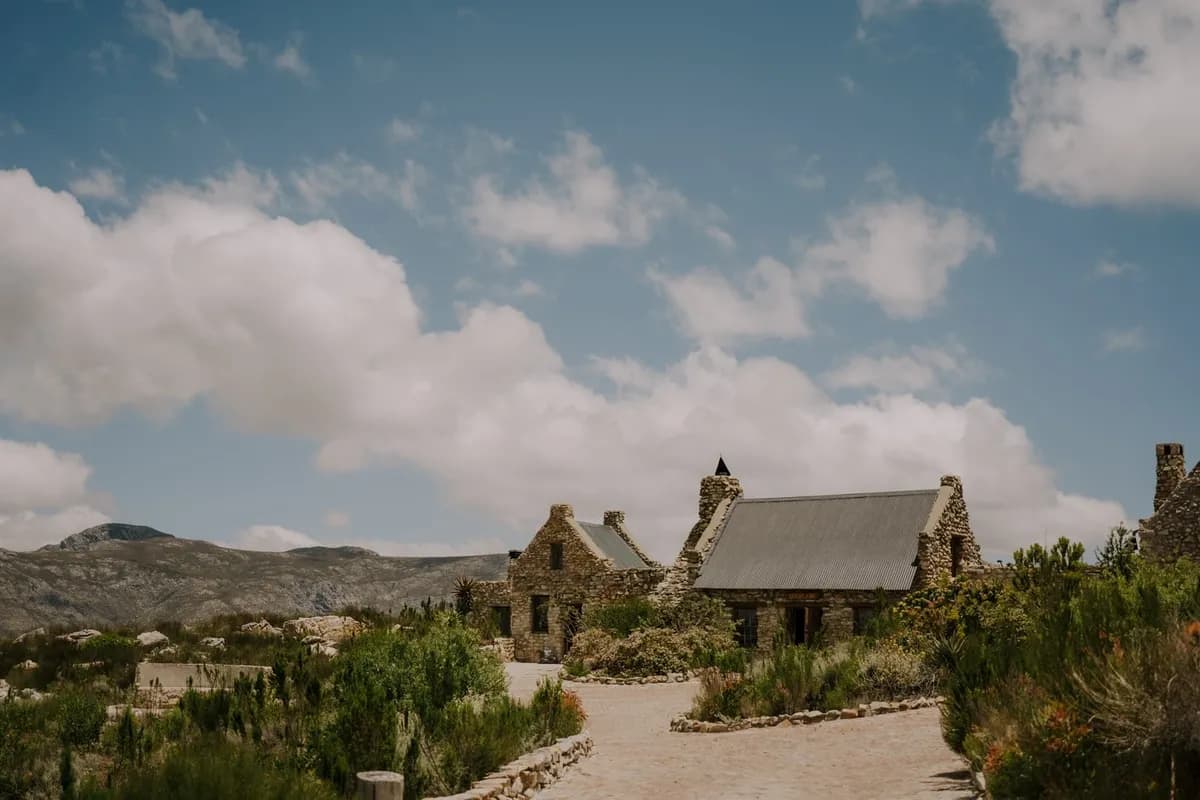 Stone cottages at Heaven's View Mountain Venue under a blue sky with soft clouds.